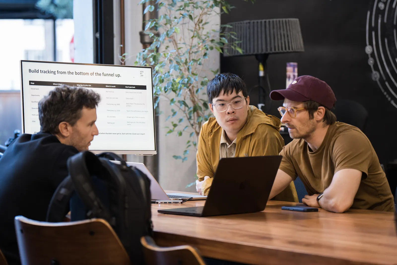 Jeremy Chung and Gui Miara working through conversion tracking with an attendee, with the slide Build tracking from the bottom of the funnel up on screen
