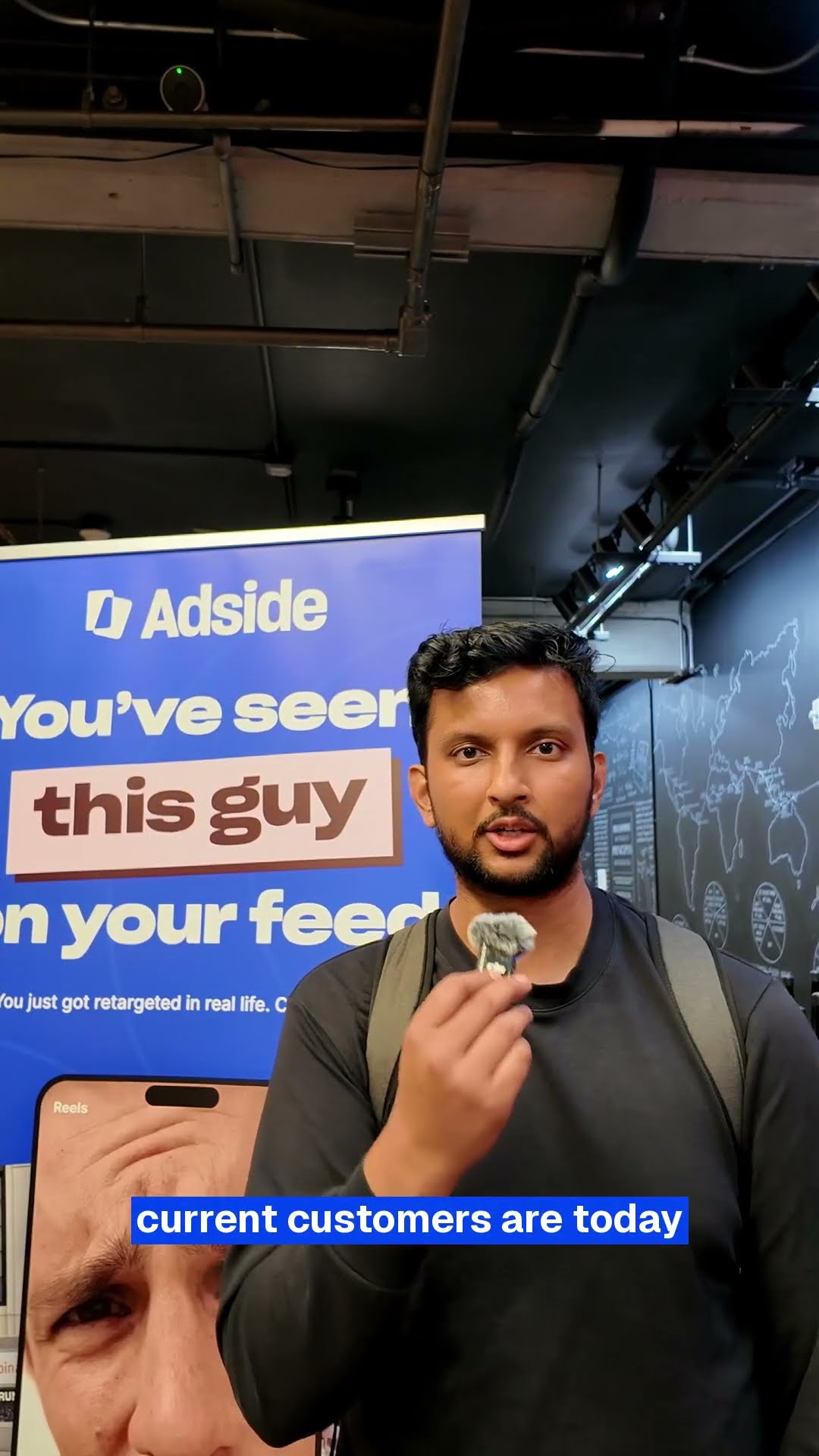Attendee talking to camera in front of the Adside banner at the October workshop